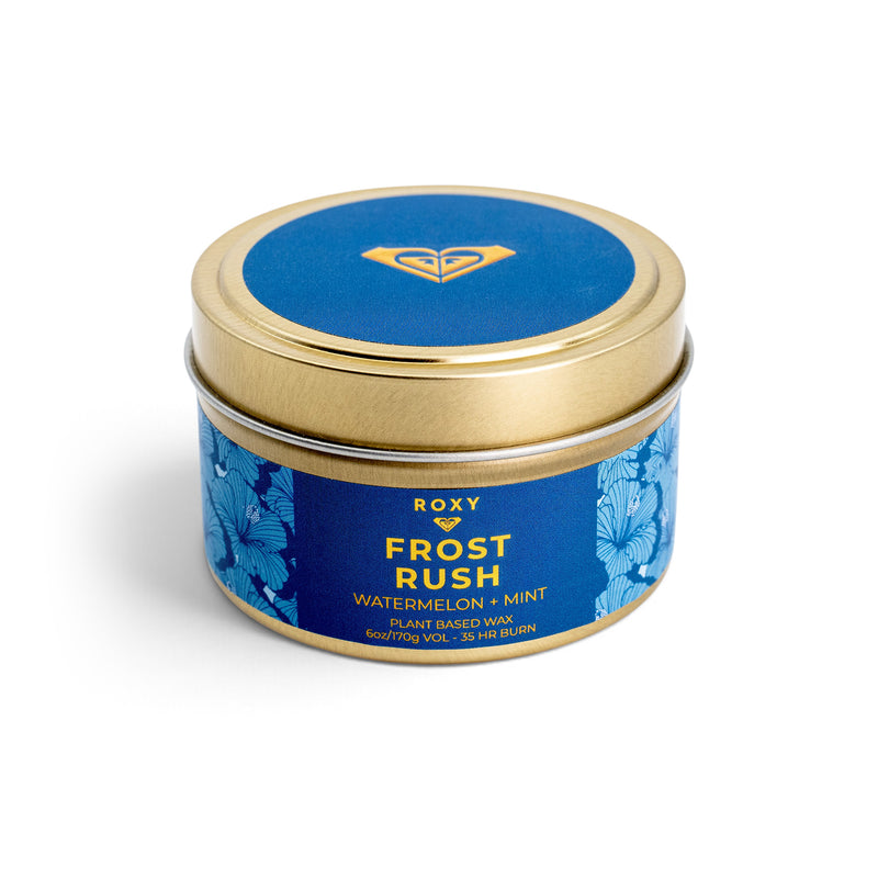 A round ROXY Frost Rush Holiday Tin Candle with a gold lid and a blue label featuring a floral pattern, text reading Frost Rush Watermelon + Mint, and notes of crisp mint.