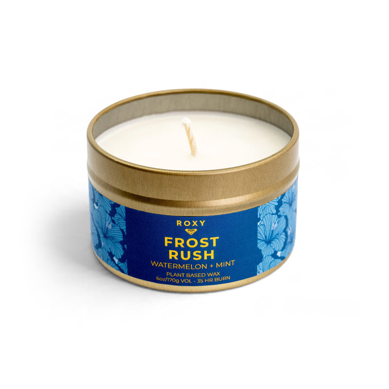 A Frost Rush Holiday Tin Candle in a gold metal tin with a blue floral label featuring notes of crisp mint and watermelon.