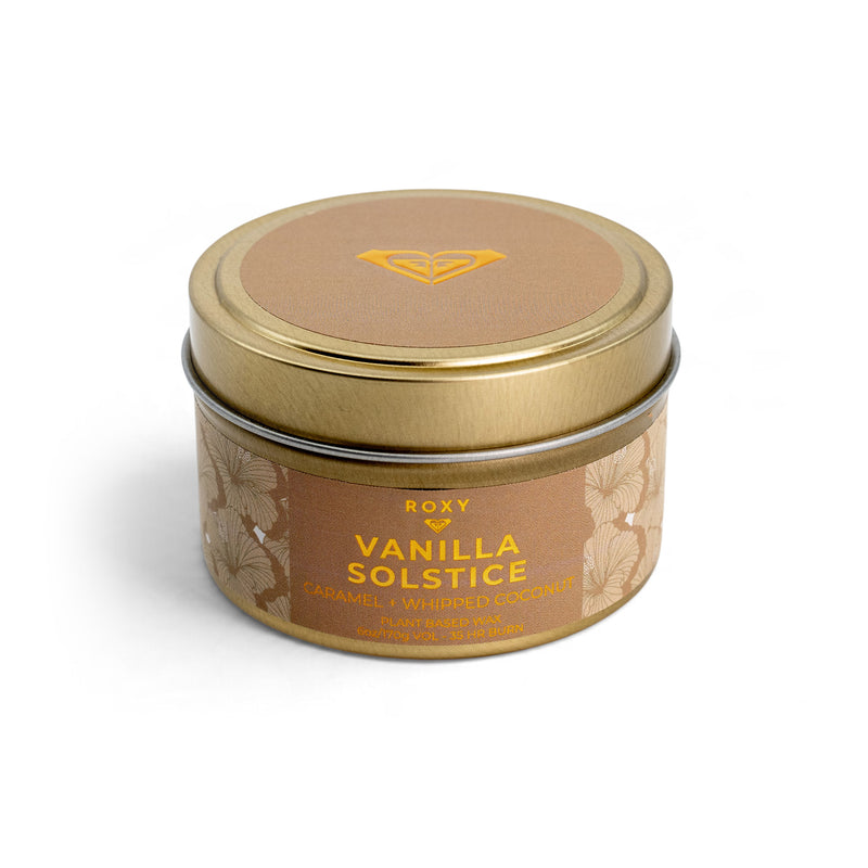 ROXY Vanilla Solstice Holiday Tin Candle in a gold-colored metal tin with a tan label featuring floral illustrations, a logo, and the scent notes of caramel honey and vanilla.