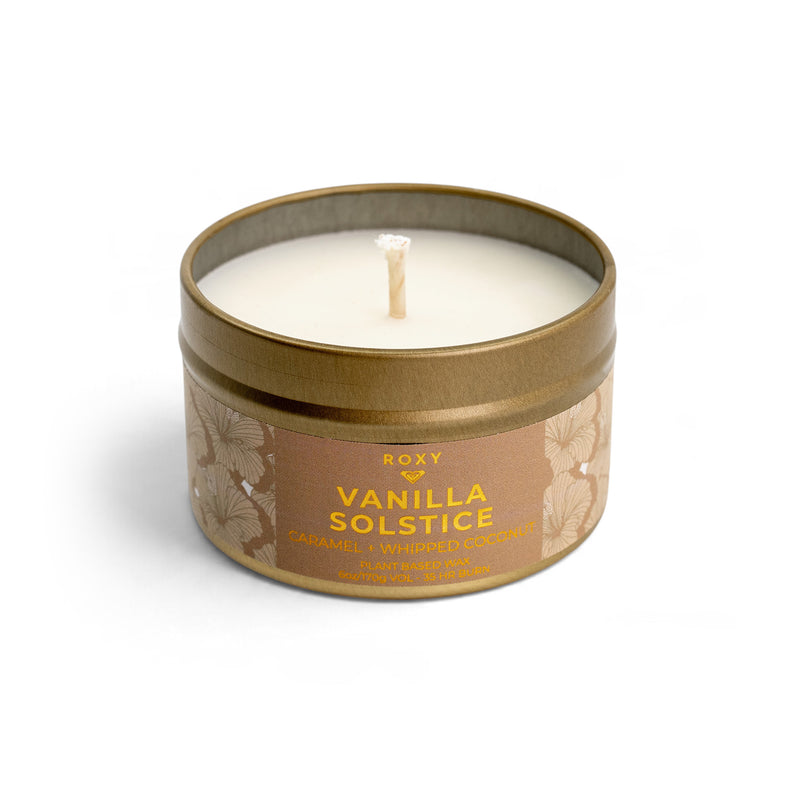 ROXY Vanilla Solstice Holiday Tin Candle in a gold tin with a white wax surface, floral patterned label, caramel honey scent, and 6oz weight indicator.