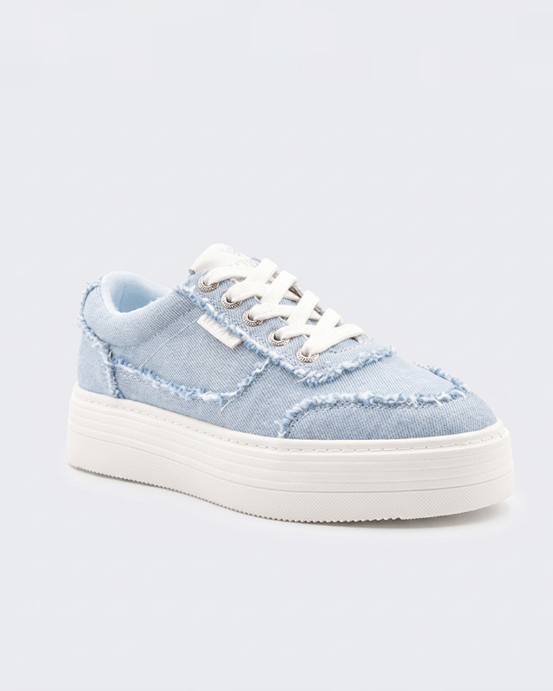The Roxy Sheilahh 2.0 Sneaker features light blue denim with frayed edges, white laces, and a chunky white rubber sole, shown against a plain light background.