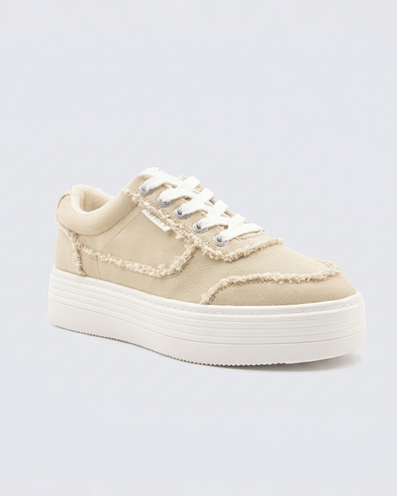 The Roxy Sheilahh 2.0 Sneaker features beige canvas with frayed edges, white laces, and a chunky white sole, shown on a light grey background.