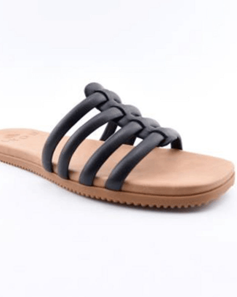 The Roxy Stellar Slip On Sandal features a tan base with a flat sole and four thick black straps crossing over the top, shown against a plain white background.