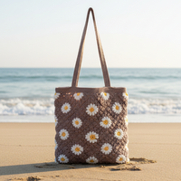 Brown crochet tote with flower motif on sandy beach