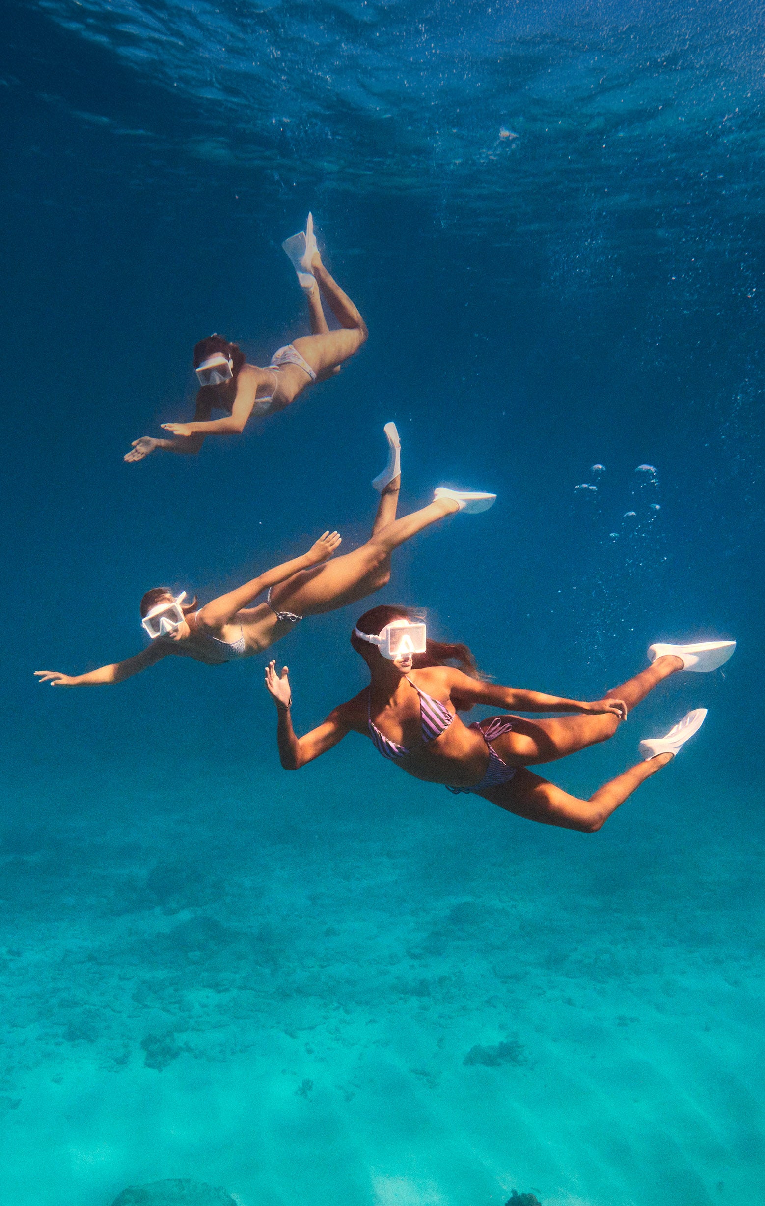 Three people snorkeling in clear blue water