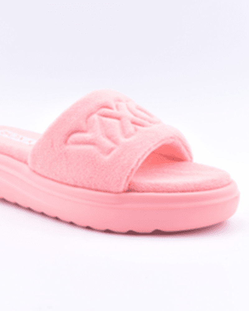 The Roxy Gelato Sandal is a single pink fuzzy slide with a thick sole and an embossed wide strap, shown against a white background.