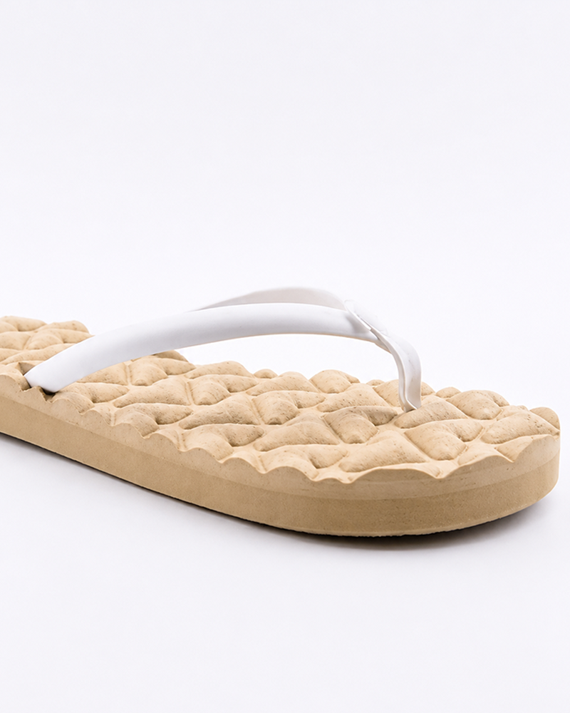 The Roxy Shoresoft Sandal in beige features a quilted, textured sole, white straps, and a cushioned footbed for comfort, shown on a white background.